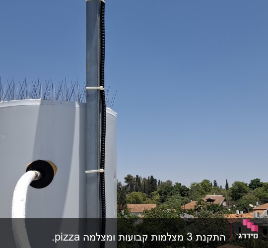 מצלמת אבטחה מותקנת על עמוד מתכת על גג
